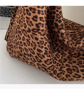 Close-up of soft leopard print fabric with golden zipper on a large tote bag