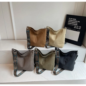 Detailed macro view of high-density canvas hobo bags with vintage patterned wide straps