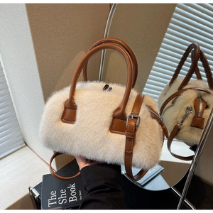 Detail view of white faux fur bag featuring brown leather handles and silver hardware