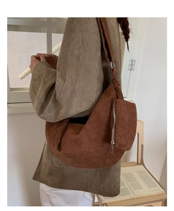 Detailed view of brown suede crossbody dumpling bag with matching zipper pouch accessory