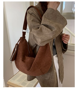 Detailed view of coffee suede crescent shoulder bag with matching mini coin purse attachment