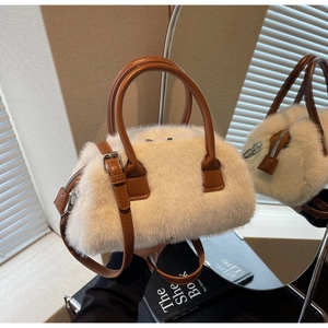 Detailed view of fluffy cream faux fur tote with brown faux leather handles and silver zipper