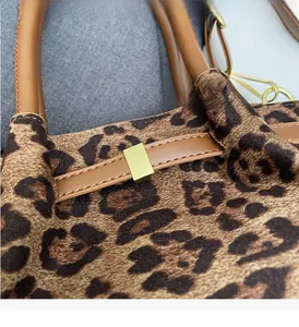 Detail der Leoparden-Handtasche mit hochwertigen Goldbeschlägen und braunem Lederriemen