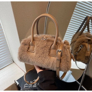 Detailed close-up of brown faux fur handbag with leather handle and metal zipper