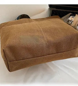 Close-up of durable dark brown canvas fabric texture on a large commuter tote bag