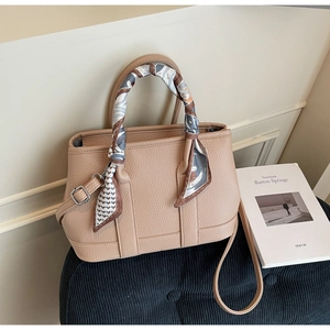 Detail view of beige lychee leather bucket bag with printed silk scarf wrap handle