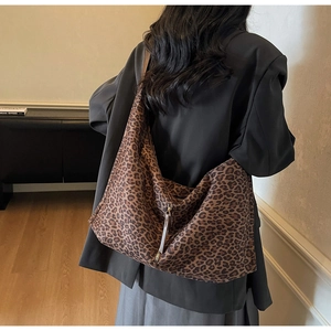 Vue détaillée du dos d'un grand sac hobo léopard porté par un mannequin en blazer noir