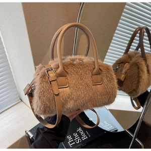 Detail of brown faux fur bag showing soft texture, leather handles, and silver hardware