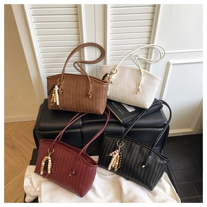 Detail of multi-color woven faux leather tote bags with stylish wooden bead pendants
