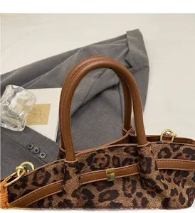 Details der Leopard-Print-Tasche mit braunen Ledergriffen und goldenen Schnallen