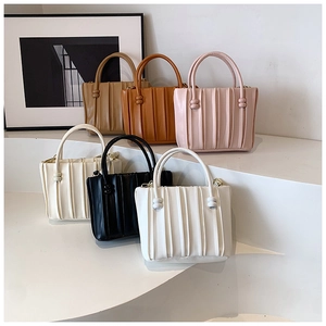 Close-up of pleated bucket handbags in multiple colors with elegant beaded handle details