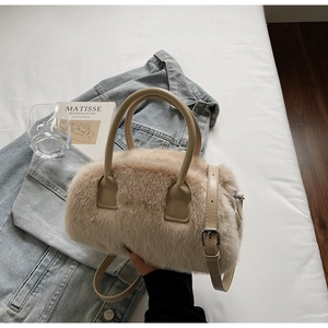 Detail of plush cream faux fur handbag featuring leather top handles and zipper closure
