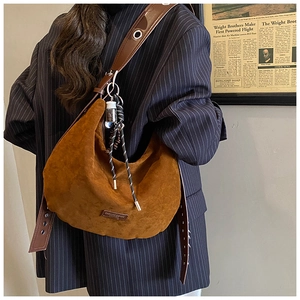 Sac croissant en daim caramel porté à l'épaule avec pendentifs décoratifs