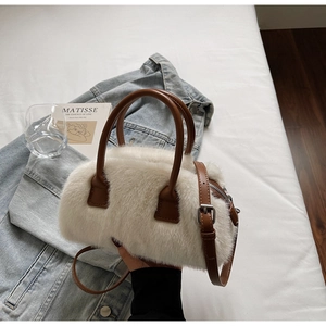 Detail of white fluffy faux fur bag with brown leather handles and adjustable strap