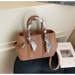 Detail of brown litchi pattern tote bag with silk scarf wrapped handle and shoulder strap