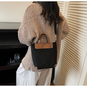 Lifestyle shot of a retro color-block hobo bag with wide strap and brown leather accents