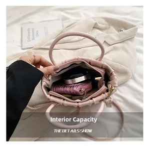 Interior view of the ruched pink handbag showing daily storage capacity and accessories