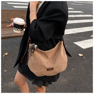 Détails du sac hobo en daim marron avec bandoulière en cuir et breloques perlées