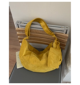 Macro shot of yellow suede hobo bag with wide strap and matching square coin pouch