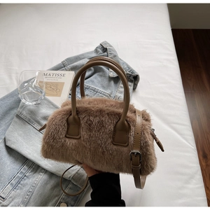 Detail of tan faux fur handbag with synthetic leather handles and metal hardware