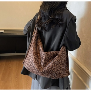 Vue de dos d'un mannequin portant un grand sac hobo léopard à la texture souple et aux tons bruns