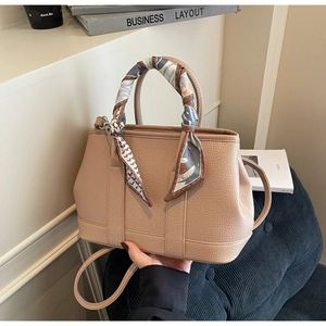 Detail of lychee pattern leather handbag with elegant twilly scarf handle decoration