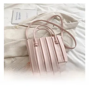 Detail of pink pleated soft leather handbag with vertical stripes and crossbody strap