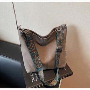 Détail d'un sac hobo vintage avec une large bandoulière colorée de style bohème