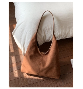 Detail showing the matte dark brown faux suede texture and stitching on the hobo tote bag