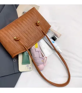 Brown woven tote bag showing large capacity for essentials like umbrella and makeup