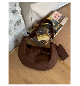 Detailed macro of dark brown suede crescent bag with matching zippered coin purse