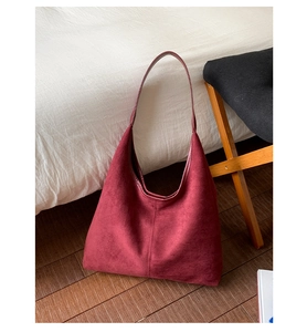 Detailed close-up of premium burgundy suede tote bag with minimalist shoulder strap design