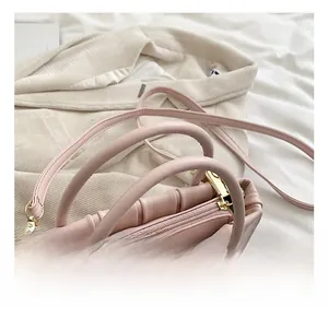 Detail of pink pleated handle and gold zipper on a retro bucket shoulder bag