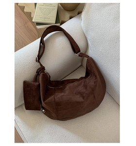 Detailed macro view of dark brown suede hobo bag with a matching mini zipper pouch