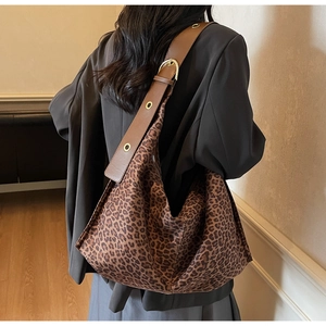 Grand sac cabas léopard en daim avec large bandoulière en cuir porté par un mannequin
