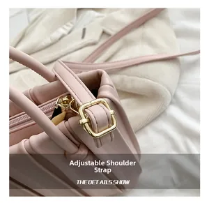 Detail shot of the adjustable shoulder strap with gold metal buckle on pink pleated bag
