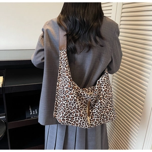 Détail du sac cabas imprimé léopard avec bandoulière en cuir brun et fermeture éclair