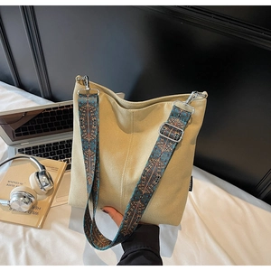 Détail du sac cabas en toile beige avec bandoulière ethnique et boucles argentées