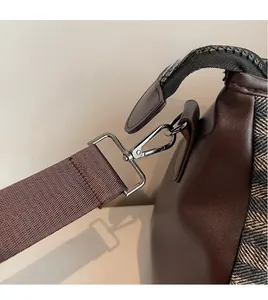Close-up of durable metal hook and herringbone weave texture on a gym duffle bag