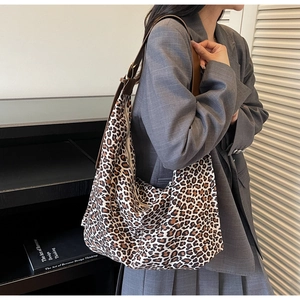 Détail du sac hobo léopard avec bandoulière réglable en cuir marron porté par un mannequin