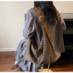 Détail du sac hobo léopard montrant la large bandoulière marron réglable avec œillets