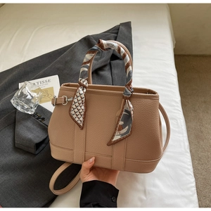 Detail of beige lychee leather handbag with silk scarf handle and detachable strap