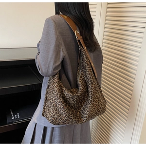 Détail du sac cabas léopard avec large bandoulière marron et boucle en métal doré brillant