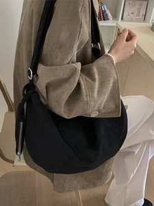Minimalist black crescent crossbody bag with mini pouch shown from a side profile