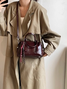 Sac Boston en cuir huilé rouge foncé avec détails argentés et pendentif tressé élégant