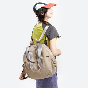 Detail of khaki nylon backpack side pocket and adjustable wide woven shoulder strap