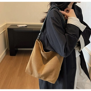 Gros plan sur un sac cabas vintage marron avec une bandoulière brodée et détails chic