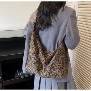 Gros plan du sac hobo en daim léopard avec fermeture éclair et garniture en cuir