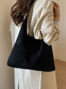 Minimalist black matte soft leather hobo tote bag for women shown on model shoulder