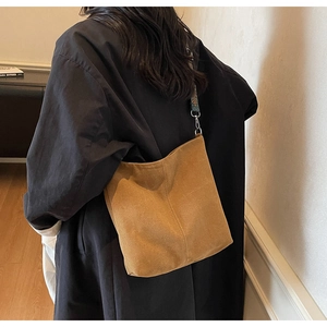 Brown faux suede tote bag with vintage geometric woven shoulder strap on black coat